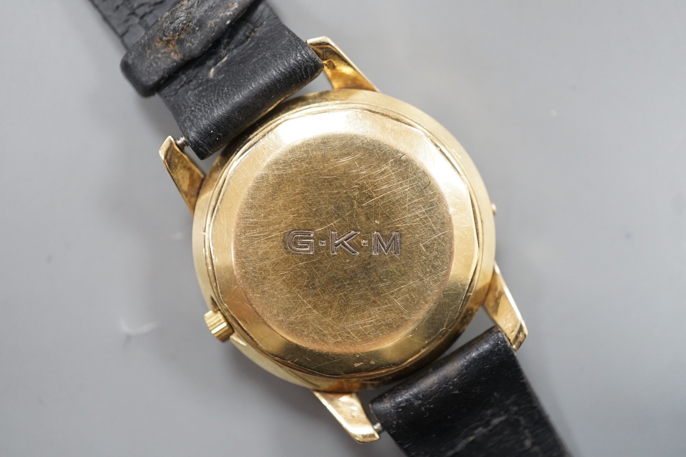 A gentleman's 14ct gold Gubelin Ipso Day automatic wrist watch, with baton numerals and date aperture, on associated leather strap, the case back with engraved initials, case diameter 35mm